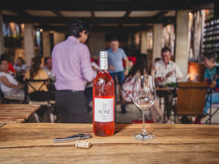 Botella de vino rosé de Finca Termópilas y una copa sobre la mesa