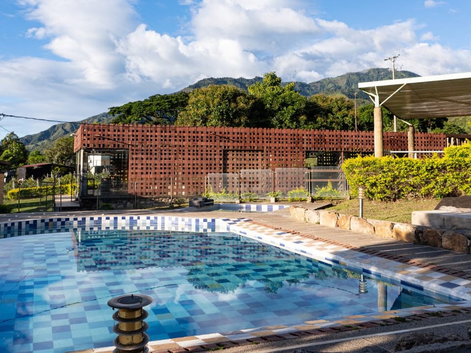 Piscina de Finca Termópilas con las montañas de Rivera, Huila, al fondo